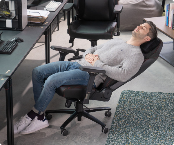 A man reclining and napping on the Secretlab TITAN Evo.