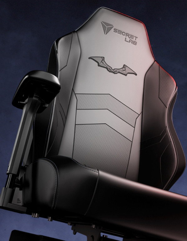 A sleek black gaming chair featuring an ergonomic design and adjustable armrests. The backrest displays a bat emblem and the 'Secret Lab' logo. The chair has a polished, textured finish and is set against a dark, gradient background.