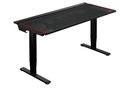 A black gaming desk with a sleek design, featuring a dark tabletop with a red trim. The desk has two sturdy metal legs for support and a small control panel on the right side. The surface displays subtle graphics in a shadowed hue.